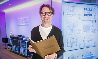 Dritte Generation: Frank Stopfel (58), hier im Eingangsbereichs seines Architekturbüros an der Schumannstraße, mit der detailreichen Chronik zum 100-jährige Bestehen des Familienunternehmens. Die verteilt er heute an besondere Gäste. - Sarah Jonek