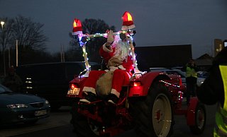 Auf einem bunt beleuchteten Traktor lässt sich der Nikolaus zum Parkplatz von Edeka Brinkmann fahren, bevor er gemeinsam mit den Kindern zum Laternenumzug loszieht. - Anthea Moschner