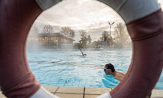 Zwei Badegäste ziehen bei einer Außentemperatur von 1 Grad ihre Bahnen im von Wasserdampf aufsteigenden Schwimmbecken von 28 Grad. - Guido Kirchner