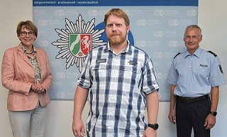 Dr. Katharina Giere und  Polizeidirektor Michael Erdmann ehrten Lebensretter D. Hennig (m.) für seinen selbstlosen Einsatz. - Polizei Bielefeld