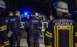 Feuerwehrleute und Polizisten stehen nach dem tödlichen Unfall an der Ummelner Straße zusammen. - Paul Brinkmann