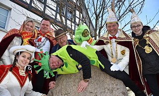 Gardetänzerin Kathi Wook, das Kranzkönigspaar Carsten und Mareike Strunz, der Vorsitzende Peter Josephs, Vize-Präsident Ralf Brüggenthies, Prinz Christian I. Hartmann und Jugendprinz Mats Carl I. Wulf (v. l.) bringen das Omikron-Virus, im Film gespielt vom zweiten Vorsitzenden Lars Rodewald, mit guter Laune zur Strecke. - Karnevalsverein Eintracht Delbrück