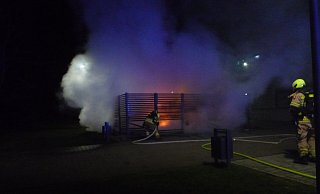 Müllcontainer in einem Unterstand auf dem Schulgelände stehen in Flammen. - Feuerwehr Paderborn