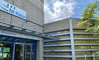 Die in die Außenfassade eingelassenen Fenster des M-Hauses der OPG sollen erhalten bleiben. Weil das Gebäude von innen gedämmt wird und der Lichteinfall bei den meisten Veranstaltungen stört, werden sie jedoch von innen abgedunkelt. - Phyllis Frieling