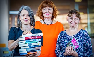 Ein Arm voller Bücher und mehr bieten die 29. Literaturtage Bielefeld, die von Angelika Teller (links) organisiert werden. Petra Josting vertritt den Förderverein der Stadtbibliothek, Iulia Capros ist Leiterin der Stadtbibliothek. - Sarah Jonek Fotografie