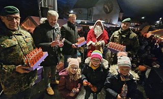Romy (v. l.), Svea und Lea halten schon die süße Gabe von Nikolaus Marco Strunk in Händen. Kompaniefeldwebel Uwe Simolka (v. l.), Bürgermeister Dirk Becker, Kamil Gorny und Fabian Herkenrath verteilen dann die nächsten Schokonikoläuse. - Knut Dinter
