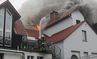 Die Feuerwehr löscht von beiden Seiten das Feuer, das sich in einem Döner-Imbiss an der Westerbachstraße in Höxter entwickelt hat. - Polizei Höxter