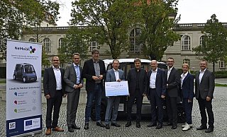An der Übergabe der Fördermittelbescheide mit Bundeswirtschaftsminister Robert Habeck (Mitte) nahmen teil: (v.l.) Thorsten Marten (Universität), CDU-Bundestagsabgeordneter Carsten Linnemann, der Parlamentarische Staatssekretär Michael Kellner, Konsortialführer Marcus Zwick (Inyo Mobility), Landrat Christoph Rüther, Jonathan Behm (Neue Mobilität), Cristina Brandtstetter (Fiware Foundation) und Projektinitiator Thomas Tröster (Universität). - BMWK/Andreas Mertens