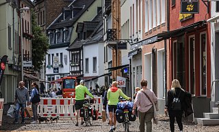 Menschen gehen durch einen Teil der Fußgängerzone in Bad Münstereifel, die noch nicht fertiggestellt ist. Knapp zwei Jahre nach der Flutkatastrophe von 2021 sind in den betroffenen Orten immer noch die Folgen sichtbar. - Oliver Berg