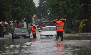 Feuerwehrleute helfen Autofahrern in Bünde, die nach dem Starkregen auf der überfluteten Engerstraße feststecken. - Florian Weyand