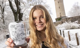 Kim Vollmers zeigt ihr Heimatliebe-Glas, welches sie zum Abschied aus Bielefeld auf den Markt bringt. - © Jörg Dieckmann - www.dieckmann-fotodesign.de