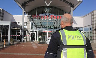 Ein Polizist bewacht am Mittwoch, 25. Oktober, den Eingang zum Werre-Park, drinnen arbeitet die Spurensicherung. Noch am Nachmittag entdeckten Ermittler das Fluchtfahrzeug in einer Scheune. - Ulf Hanke