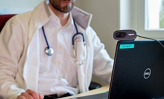 Ein Hausarzt spricht während einer Videosprechstunde in seiner Praxis mit einer Patientin. - picture alliance/dpa/dpa-Zentralbild