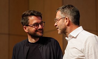 Marc Herter (r), Interimsvorsitzender der NRW-SPD, spricht mit Ex-Landesparteichef Thomas Kutschaty beim Konvent in Münster. - Friso Gentsch