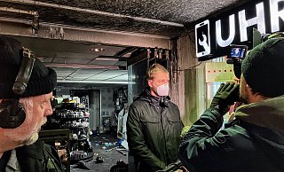 Brandermittler Philipp Schröder gibt vor dem ausgebrannten Tedi-Markt im Jahnplatz-Forum dem WDR ein Interview. Ein technischer Defekt als Ursache ließ sich ausschließen. - Jens Reichenbach