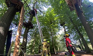 Über eine Leiter steigen die Höhenretter der Paderborner Feuerwehr in den Kletterparkour ein, um den Jugendlichen zu sichern und dann abzuseilen. - Marc Schröder