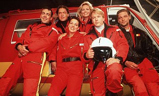 Die erste Crew von "Medicopter 117": Ralf Staller (v. l.), Dr. Michael Lüdwitz, Biggi Schwerin, Dr. Gabrielle Kollmann, Peter Berger und Thomas Wächter. - imago images / United Archives Die erste Crew von "Medicopter 117": Ralf Staller (v. l.), Dr. Michael Lüdwitz, Biggi Schwerin, Dr. Gabrielle Kollmann, Peter Berger und Thomas Wächter. - imago images / United Archives