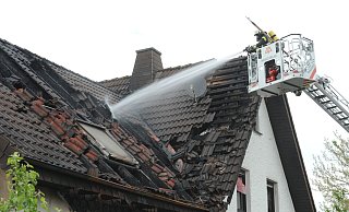 Von der Lübbecker Drehleiter aus öffneten die Feuerwehrleute die Dachhaut, suchten nach Glutnestern und löschten sie ab. - Joern Spreen-Ledebur