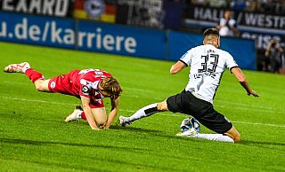 Arminia Bielefelds Henrik Koch (l.) foult Felix Higl und wird dafür mit Gelb verwarnt. Wenig später fliegt der 17-Jährige vom Platz. - IMAGO/Nordphoto