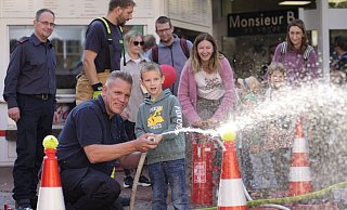 Feuerwehrmann Frank Hülshorst half den Kindern beim Zielen. Mama im Hintergrund sorgte an der Kübelspritze für den Wasserdruck. - Gerald Dunkel