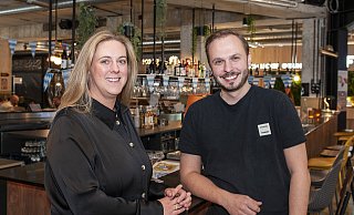 Der Harms-Markt hat jetzt zwei Manager: Patrick Miles (31) unterstützt seit August Sarah Seebode (41). Ihr Lieblingsplatz in der Markthalle: "Mittendrin", sagen beide. Wie hier an der Bar. - Joerg Dieckmann - www.dieckmann-fotodesign.de