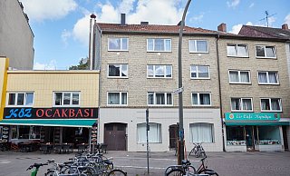 Blick auf das Mehrfamilienhaus in Hamburg-Harburg, aus dem ein Junge in die Tiefe stürzte. Links daneben das türkischen Restaurant, dessen Gäste die Tragödie mit ansehen mussten. - (c) Copyright 2023, dpa (www.dpa.de). Alle Rechte vorbehalten