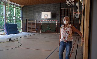 Auch die Sporthalle stand vergangenes Jahr nach dem Starkregen unter Wasser. Schulleiterin Annegret Holz wirft einen Blick hinein. - Mareike Patock