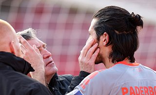 SCP-Mannschaftsarzt Matthias Porsch und Physiotherapeut Robert Wezorke (r.) checken den Gesundheitszustand von Marcel Correia, der in einem Kopfballduell mit einem Nürnberger Gegenspieler zusammengeprallt war. - picture alliance / Sportfoto Zink / Daniel Marr