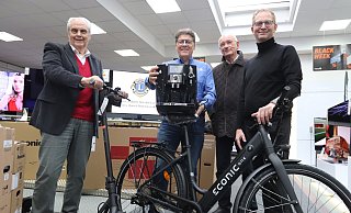 Dietrich Goldstein, Rainer Döring, Eckhard Augustin und TIm Schütte von den Löhner Lions zeigen einige der Gewinne. Dazu gehören E-Bike und E-Scooter genauso wie ein Kaffeevollautomat. - Judith Gladow