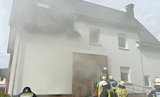 Dichte Rauchwolken hüllen das Zweifamlienhaus in der Straße Graben im Bürener Stadtteil Brenken ein. - Feuerwehr Büren
