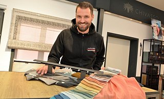 Daniel Brock (40) beherrscht die gesamte Palette der Raumausstattung von Gardinen über Bodenbeläge bis hin zu Markisen, von denen er Muster in den Ausstellungsräumen zeigen kann. - Karin Prignitz