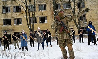 Ein Soldat trainiert in Kiew Zivilisten, die hölzerne Waffenattrappen tragen. - AFP or licensors