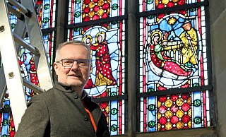 Der Kirchenkreis Herford ist derzeit wie eine Baustelle. Superintendent Olaf Reinmuth hat daher auch kein Problem, für den NW-Fotografen auf eine Leiter zu steigen. So ist er den Weihnachtsmotiven in den Fenstern der Johanniskirche am Neuen Markt in Herford näher. - Frank-Michael Kiel-Steinkamp
