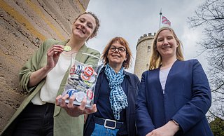 Mit der flatternden Burgfahne über den Köpfen: Jill Mallin (von links), Gabriela Lamm und Jacqueline Heger von Bielefeld Marketing werben mit Bi-Schoko-Talern für ihre Freizeitangebote. - Mike-Dennis Mller / www.mdm.photo