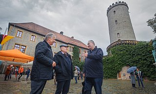 Am Fuße des zur Feier des Tages Schwarz-Rot-Gold beflaggten Turmes der Sparrenburg begrüßen der CDU-Kreisvorsitzende Andreas Rüther (l.) und der Landtagsabgeordnete Ralf Nettelstroth (r.) ihren Gastredner Rainer Eppelmann. Foto: Sarah Jonek - Sarah Jonek Fotografie