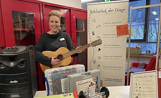 Die Gitarre, die Mareike Koch in den Händen hält, kann man in der Sadtbücherei ausleihen. Aber auch die anderen Dinge, wie die Karaoke-Maschine, das Energiespargerät, den Hesherball, das Hantelscheiben-Set, die beliebten "Kekzhörer" oder den Lesebär auf dem Foto. - Elke Niedringhaus-Haasper