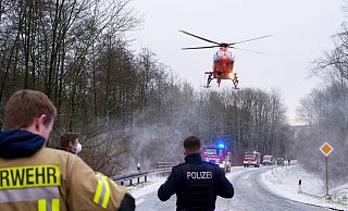 Einsatzkräfte der Feuerwehr Altenbeken beobachten die Landung des Rettungshubschraubers "Christoph 13" an der Altenbekener Unfallstelle. - Ralph Meyer
