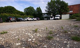 Der öffentliche Parkplatz am Schelmenbrink ist sanierungsbedürftig. Deshalb machen sich drei Vereine für einen Ausbau stark. - Niklas Krämer