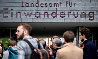 Menschen stehen vor dem Berliner Landesamt für Einwanderung. Ausländer in Deutschland sollen nach Plänen der Bundesregierung bald leichter eine deutsche Staatsangehörigkeit erhalten können. - Britta Pedersen/dpa