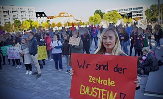 Hülya Arslan demonstriert mit einem roten Plakat auf dem Kesselbrink. Zum zweiten Mal geht die Initiatorin der Online-Petition mit ihren Mitschülern auf die Straße, um für den Erhalt des AWO-Berufskollegs zu kämpfen. - Mike-Dennis Müller