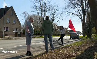 Erregte Szene: Schwungvoll tritt die Verlobte des Terrorverdächtigen Thomas N. vor dessen Haus in der Kutenhauser Straße gegen das am Boden liegende Stativ des Fernsehteams. Ihr Sohn (links) hat sich Handschuhe angezogen. - ZDF