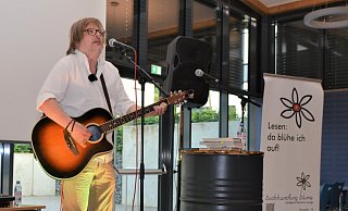 Der Bielefelder Straßenmusiker Stefan Just unterhält in der Mensa der Heinz-Sielmann-Schule seine Zuhörer mit seinen literarischen Ausflügen und seinen Songs zum Gitarrenspiel. - Karin Prignitz