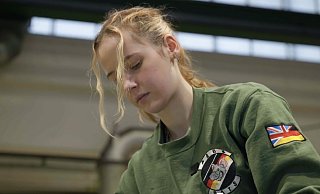 Jasmin ist leidenschaftliche Schrauberin für die britische Armee. An ihrem Ärmel die deutsche Fahne und der Union Jack. - Screenshot
