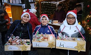 Lukas, Joshua und Damian (v.l.) aus der 4a der St. Marien-Grundschule verkaufen Plätzchen. "Wir haben unseren Eltern beim Backen geholfen", versichern sie. - Regina Brucksch