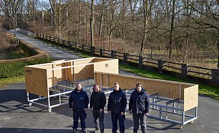 Benjamin Scholz (v. l.), Bruno Eikel, Philip Millek und Sascha Werner von den Werkstätten für raumbildende Konstruktion vor dem Gerüst, auf dem das Kreuz transportiert wird. - Werkstätten für raumbildende Konstruktion