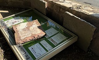 Der zerstörte Schaukasten liegt hinter der Kirchmauer. - Kirchengemeinde Mennighüffen