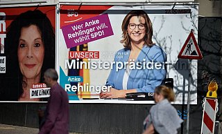 Menschen gehen im Saarland an einem Poster vorbei, das für die SPD-Politikerin Anke Rehlinger wirbt. - JEAN-CHRISTOPHE VERHAEGEN/AFP