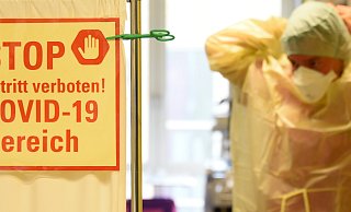 Im Krankenhaus St. Elisabeth und St. Barbara Halle/Saale zieht sich auf der Covid-Station ein Pflege Schutzkleidung an. Auf der Station ist seit dem heutigen Tag eine deutliche Entspannung mit Belegung von Covid-19 zu spüren. - picture alliance