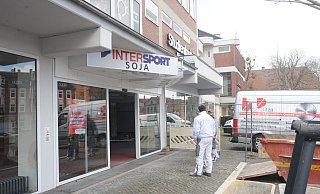 Noch ist über den ehemaligen Geschäftsräumen die Intersport-Soja-Werbung angebracht. Doch Handwerker sind am Markt in Lübbecke bereits aktiv und bereiten innen alles für die künftige Nutzung durch Discounter Tedi vor. - Joern Spreen-Ledebur