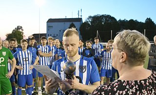 Da ist er: Angelika Dobbersalzke, Kassierein des Fußballkreises Minden, übergibt FCO-Kapitän Kevin Reimer den Pokal. - Jürgen Krüger